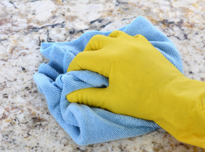 Hand in Yellow Latex Glove With Blue Towel